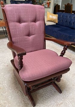 A classic wooden high-back glider rocker