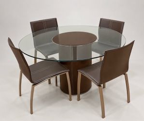 modern round glass-top dining table with four matching brown faux-leather upholstered chairs.