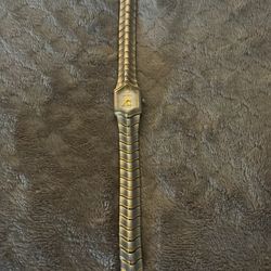 Croton two-tone quartz women's watch featuring a wave-link bracelet.