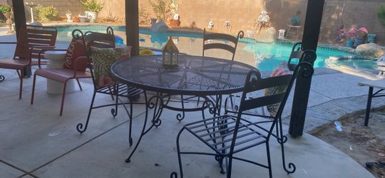 Wrought iron table and four chairs good condition table size. 48” different