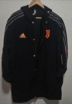 Adidas Juventus Travel Jacket, black design with orange branding.Brand: AdidasTeam: Juventus FCStyle: Hooded Travel Jacket  (model FR4202)Details: Bla