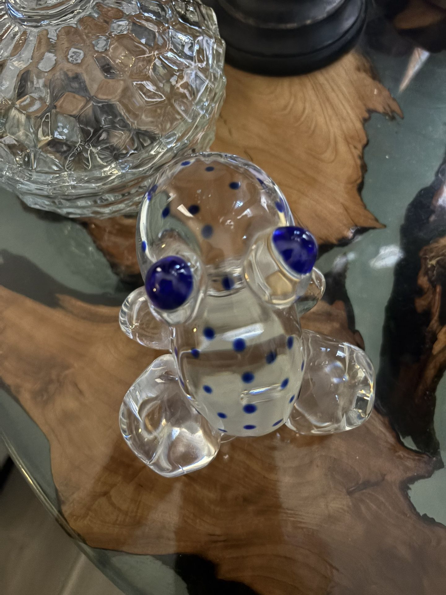 Art glass paperweight frog is clear glass with blue eyes and spots. He is signed on the bottom as shown in the pictures and made in Poland.