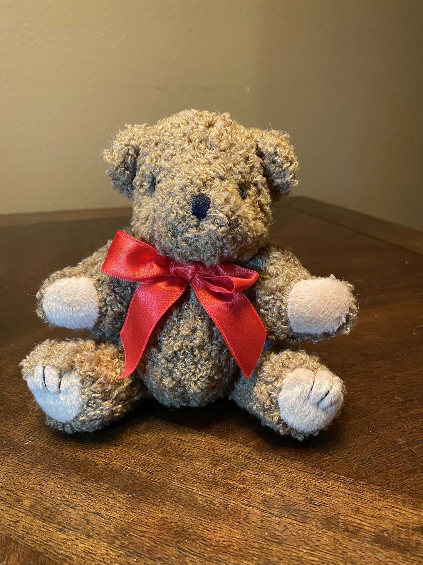 Sitting teddy bear with red bow