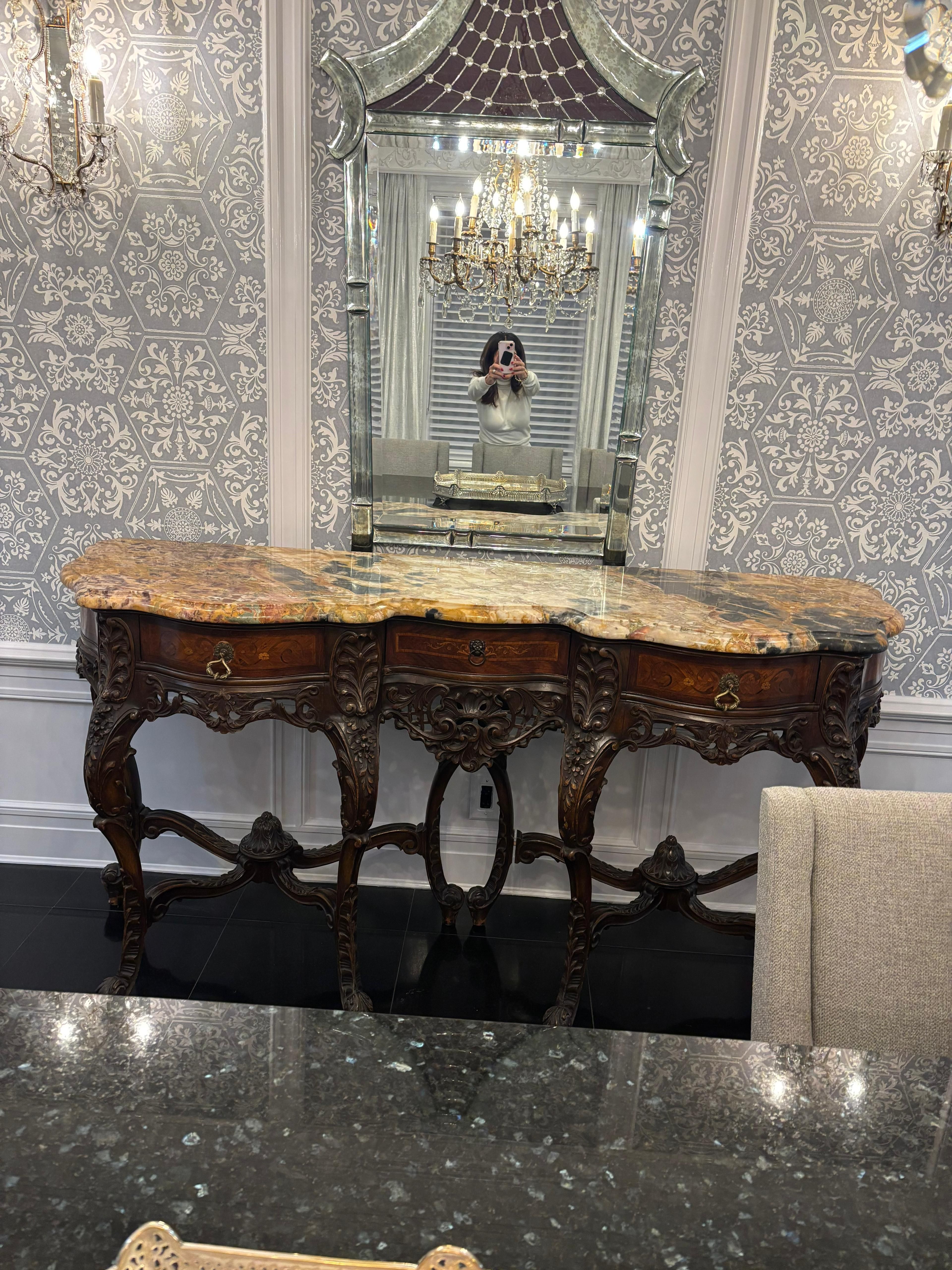 Carved wood console table with a marble top