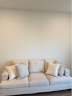 Cream-colored sofa with 4 pillows included.