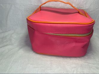 Pink makeup bag with orange lining and zipper closure