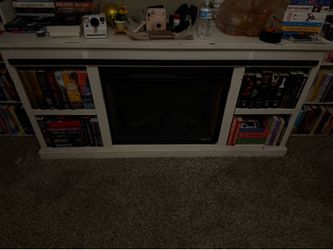 White wooden electric fire place with built in shelves