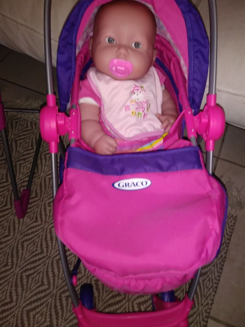 Large baby doll w/ Graco doll stroller & various outfits including doll accessories.
