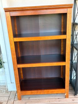Wood bookcase with a 3 shelf design with a dark interior panel