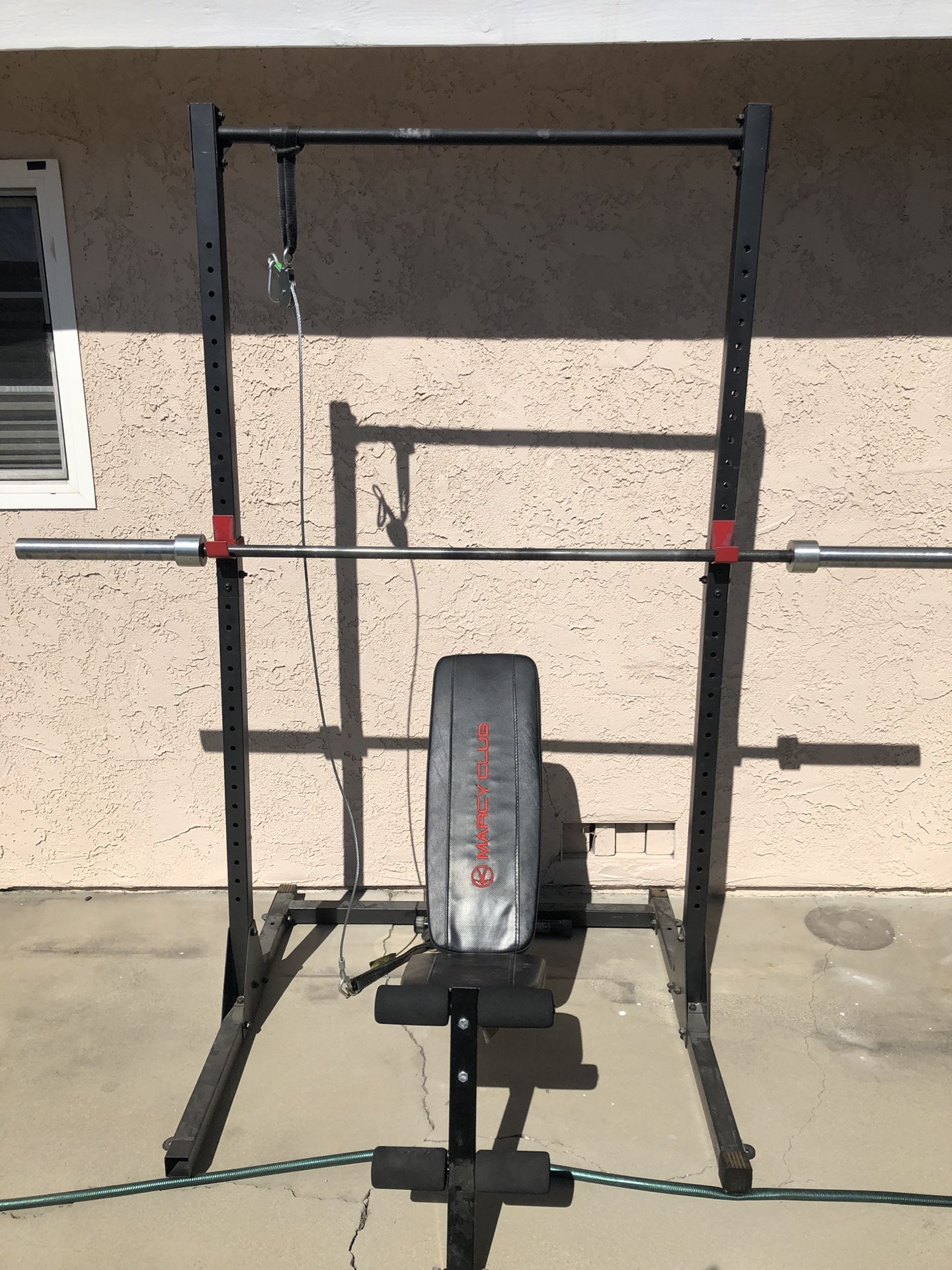 Squat rack with pulley and bench, curl bar, and cable attachments
