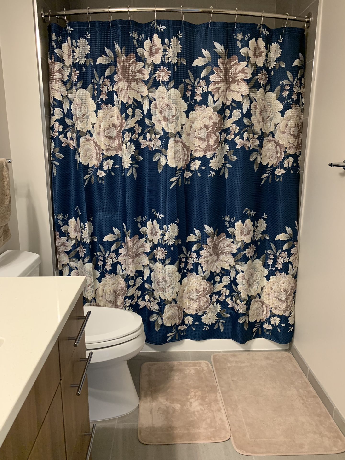 shower curtain with hooks and two bath mats .