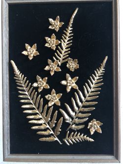 Framed Hawaiian flowers that are plated with gold