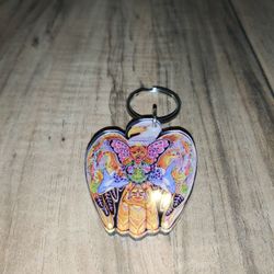 Sue Coccia Earth International Eagle Graphic Keychain. Has some wear from age and use. Sold as is.

