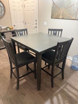 Tall dining room table with chairs.