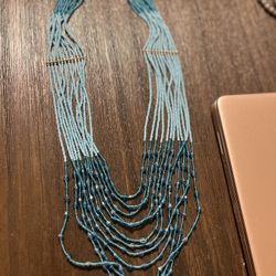 Beaded Necklace. The Beads Are Light, Turquoise And Dark Turquoise With Metal In Between.