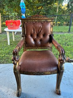 Hand-carved wooden armchair upholstered in brown leather… $75