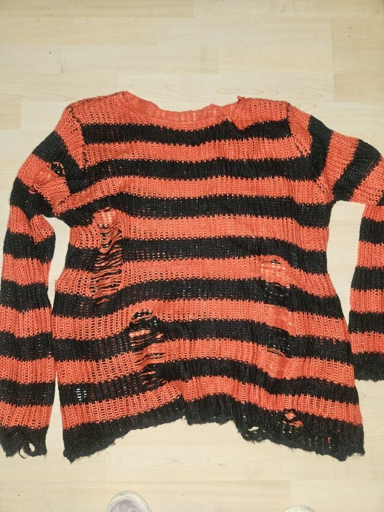 Orange and black oversized sweater with holes in used as a Freddy Krueger Halloween Costume