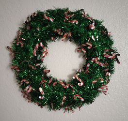CHRISTMAS WREATH, WALL DOOR HANGING. GREEN TINSEL WITH RED AND WHITE STRIPED CANDY CANES