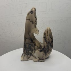 sculpture of a howling wolf made of ceramic with horsehair, created by the