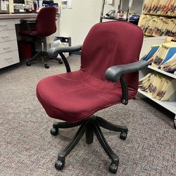 Rolling red and black, pneumatic adjustable height chair. Perfect for an office or nonprofit.