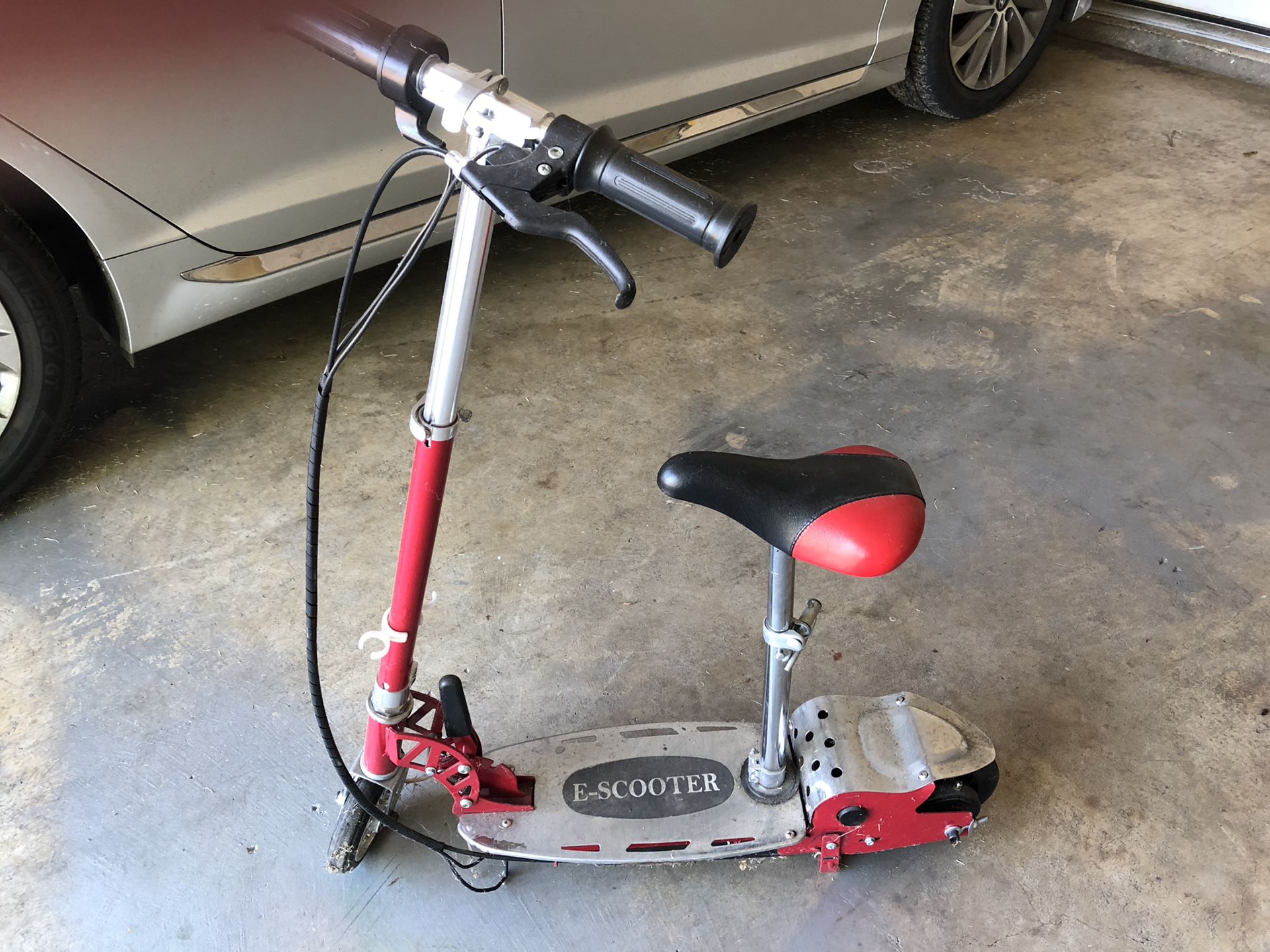 Childs electric scooter with brakes and adjustable seat. A bit dirty from sitting in the garage but has charger and works good.