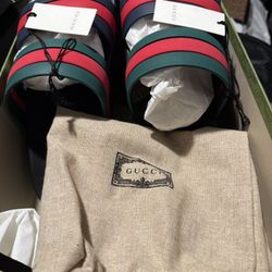 This is a pair of Gucci Agrado GRG Rubber Slides in black with blue, green, and red stripes
