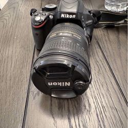 Nikon D5100 with 18-200mm lens, 18-55mm lens, battery x2, charger, and carry case with water cover