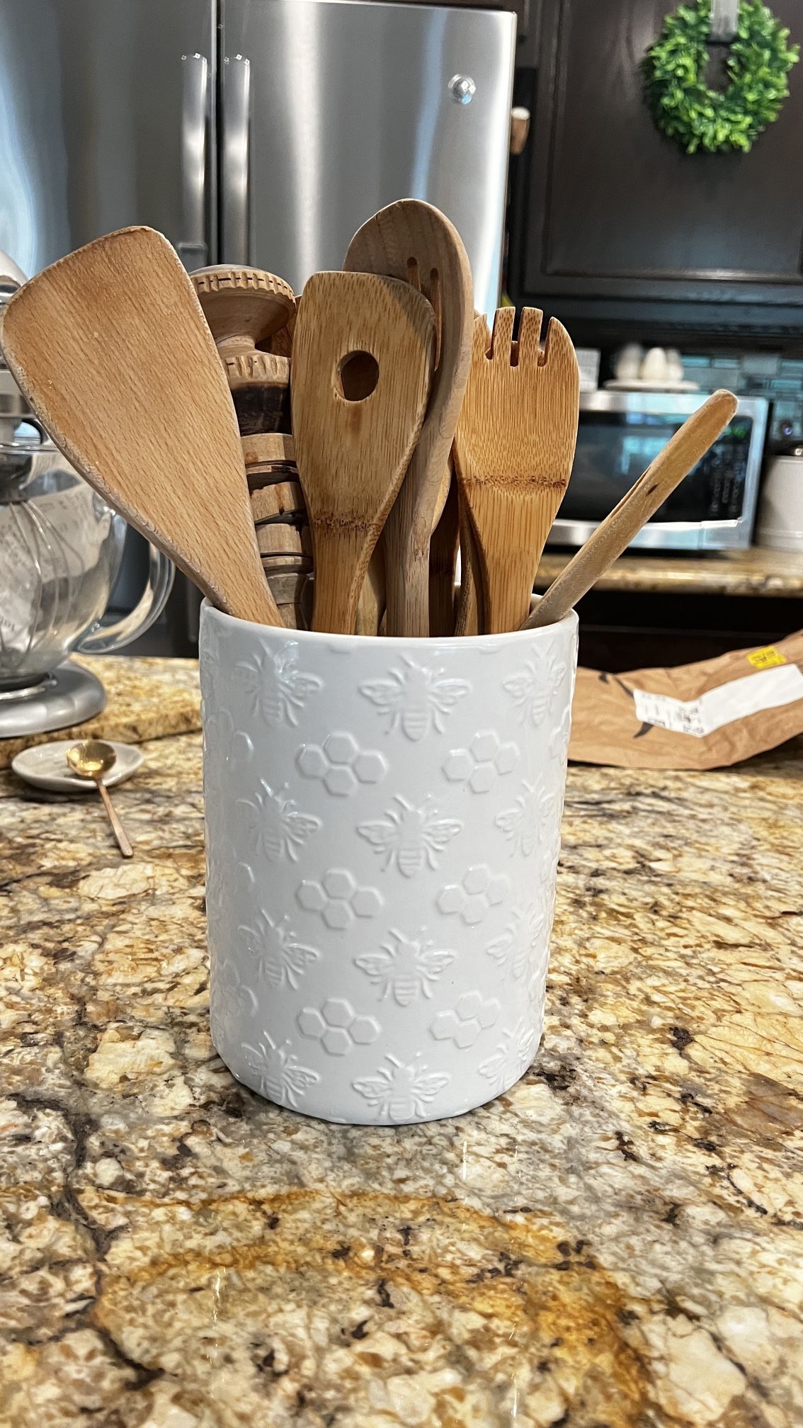 White Ceramic Kitchen Utensil Holder With Wooden Assortment Of Spoons