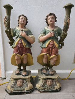 pair of polychrome carved wooden figural candleholders,