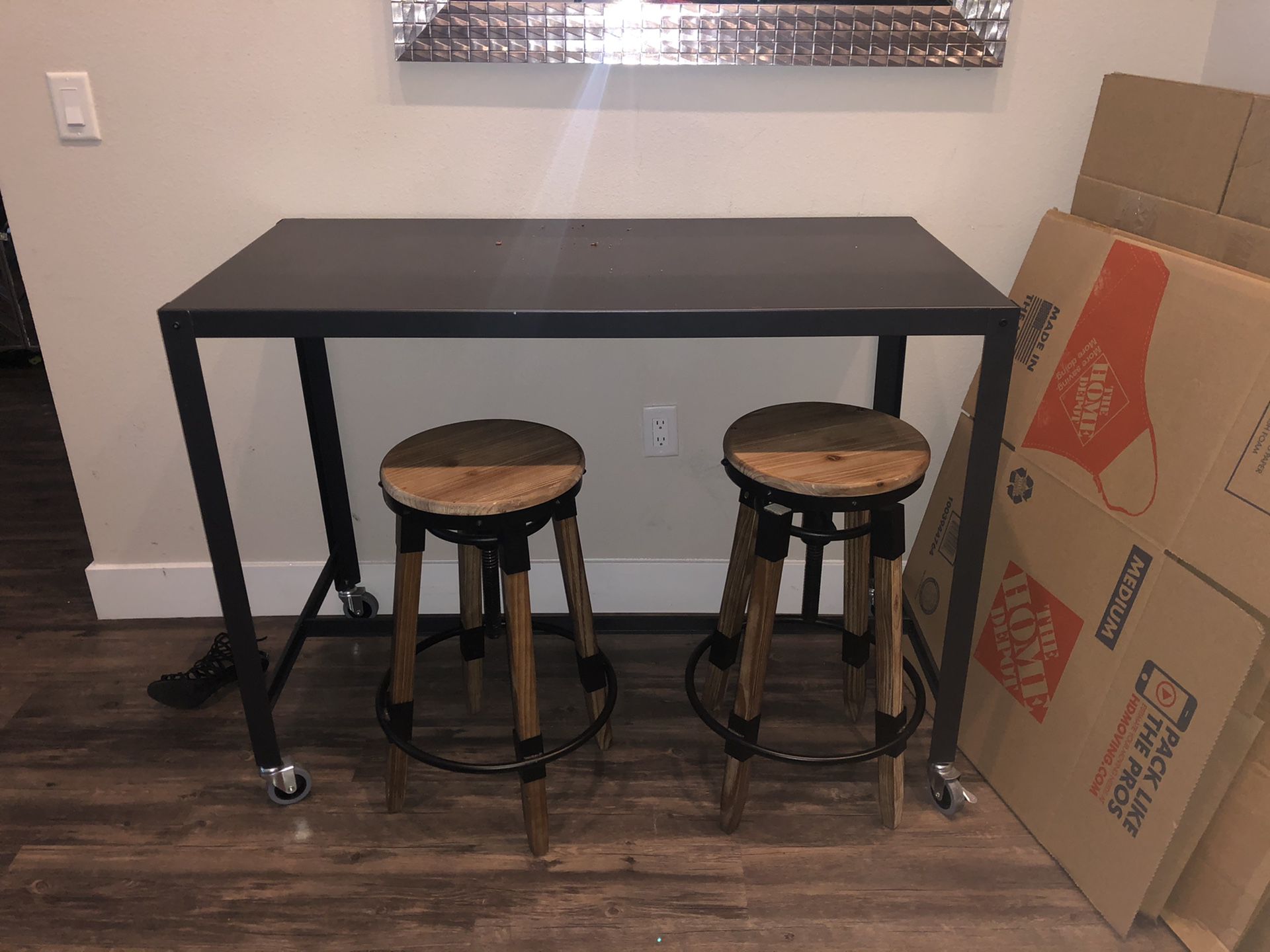 Black industrial style bar top table with two adjustable stools