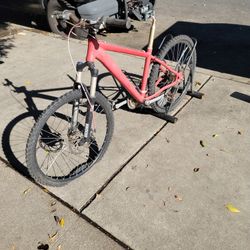 The image displays a red hardtail mountain bike.