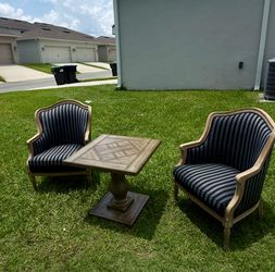 Selling 2 bergère-style armchairs with carved wood + a table.