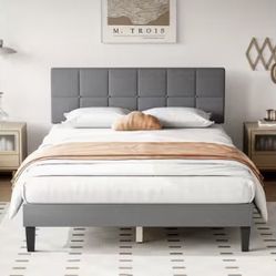 Grey upholstered bed frame with tufted headboard