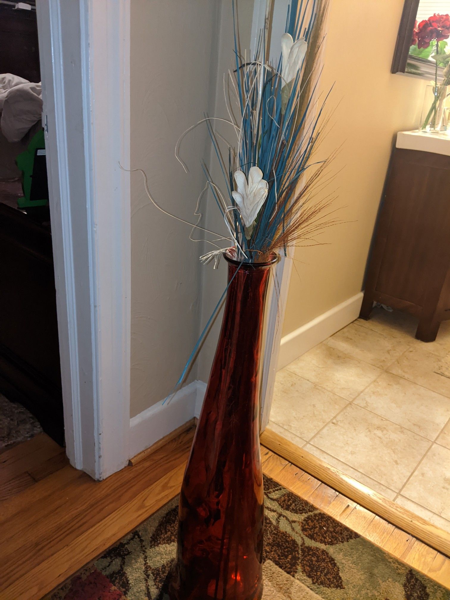 Red glass floor vase with flowers