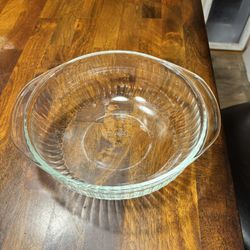  Pyrex 2-quart clear glass round casserole dish with ribbed sides and handles.