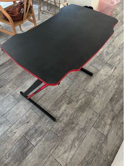 Black desk with red trim and headphone holder