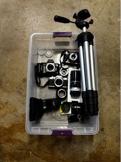 3 Cameras  ( 2 working ) with  Lenses , tripod  and accessories for use , repair or parts .