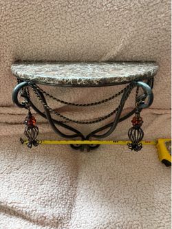 Metal shelf not real marble, but put together very well and the colored metal tassels are acute touch