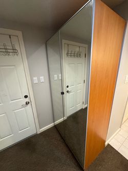 Two section vintage  IKEA PAX wardrobe features mirrored doors.