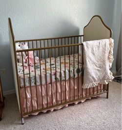 Gold crib with linen side accent turns to toddler bed