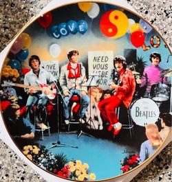 This decorative porcelain collector's plate is a 1992 Delphi release featuring The Beatles themed around the song "All You Need Is Love