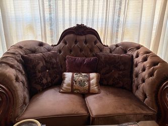 This furniture piece is a traditional European-style carved wood loveseat,