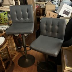 Pair of height-adjustable grey faux leather swivel bar stools