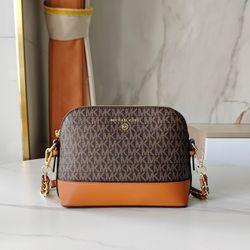 Ms. MK is carrying a small shell-shaped bag over one shoulder.