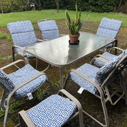 Patio furniture set: dining table, 6 armchairs, and 2 foot rests