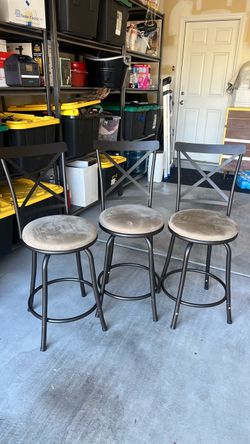 Three bronze and tan suede bar stools