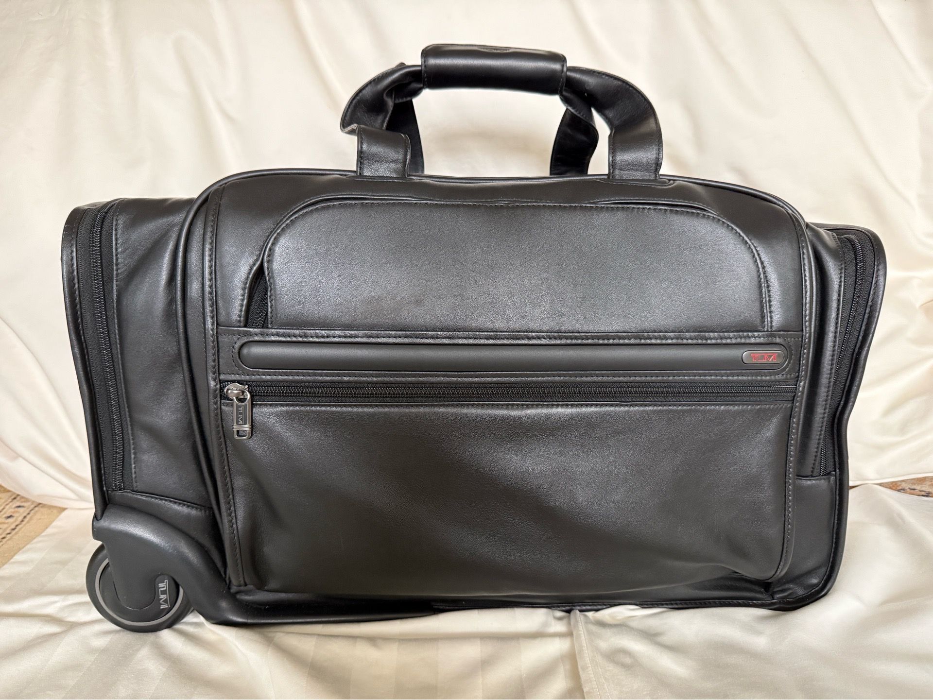 TUMI Black Leather carry on bag; never used.