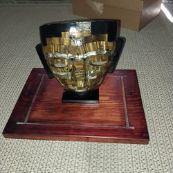 Stone mask on wood stand in glass case made in mexico