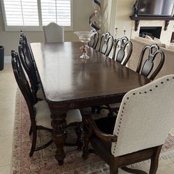 table with 10 chairs and side board and mirror