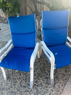 Two patio chairs with cushions